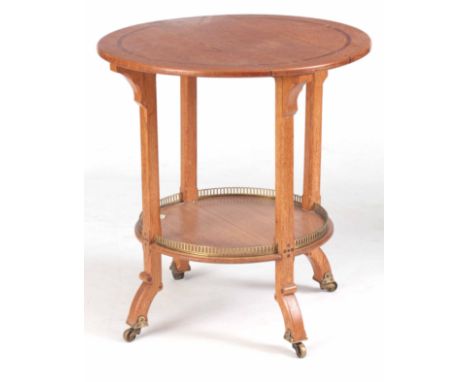 AN ARTS &amp; CRAFTS INLAID MAHOGANY OAK CIRCULAR OCCASIONAL TABLE with under shelf having a brass gallery; standing on squar