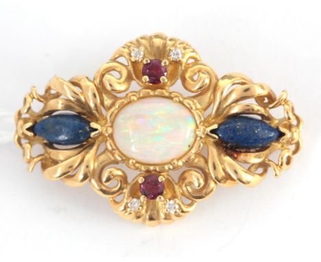 AN 18K YELLOW GOLD BROOCH set with oval opal to center, rubies, diamonds, and lapis lazuli 36mm diameter, app. 9.5g