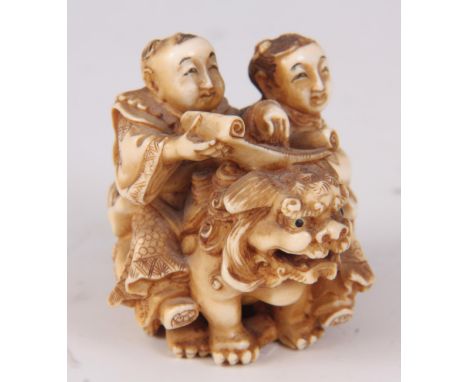  A FINE MEIJI PERIOD JAPANESE NETSUKE depicting two scholars sat on a foo dog reading scrolls - signed to the underside with 
