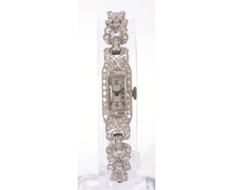 A LADIES VINTAGE PLATINUM AND DIAMOND SET COCKTAIL WATCH the case enclosing a silvered Art Deco dial with Arabic numerals fro