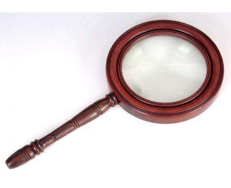 AN EARLY 19TH CENTURY MAHOGANY AND ROSEWOOD LIBRARY GLASS having turned moulded surround, enclosing a 5.5" magnifying glass 3