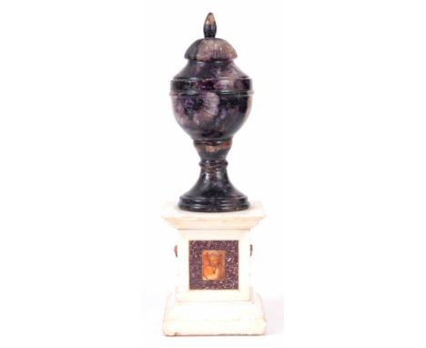 A 19TH CENTURY BLUE JOHN URN with gadrooned top and circular foot standing on square white marble moulded base inset with por