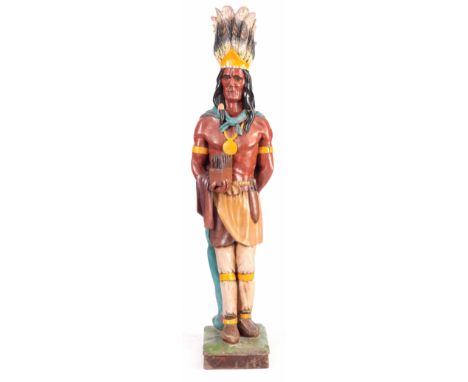 AN AMERICAN VINTAGE PAINTED WOODEN INDIAN CHIEF TOBACCO SHOP ADVERTISING STATUE the carved figure with full headdress holding