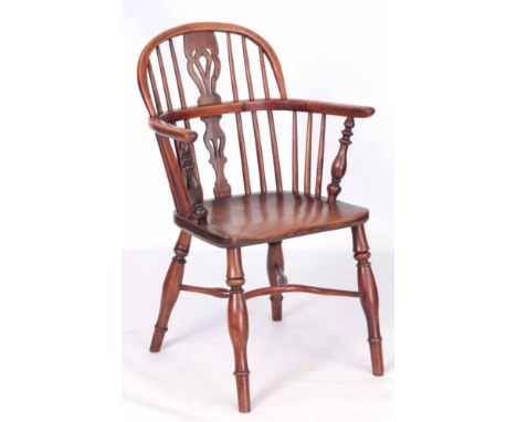 A 19TH CENTURY YEW-WOOD LOW BACK WINDSOR CHAIR with pierced shaped splat hooped back and elm saddle seat; standing on ring tu