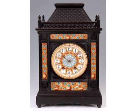 A LATE 19TH CENTURY AESTHETIC  EBONISED AND PORCELAIN PANELLED BRACKET CLOCK having a simulated carved slate roof pediment wi