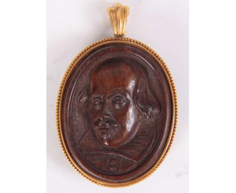 AN EARLY VICTORIAN 18K GOLD AND MULBERRY WOOD CARVED PENDANT depicting a portrait of William Shakespear, the mulberry wood is
