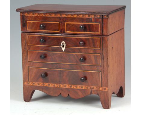 AN INTERESTING EARLY 19TH CENTURY FIGURED MAHOGANY NOVELTY TEA CADDY formed as a miniature chest of drawers with dummy boxwoo