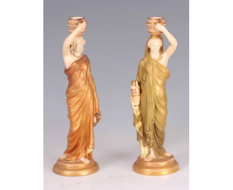 A PAIR OF EARLY 20th CENTURY ROYAL WORCESTER PORCELAIN FIGURES modelled as two Grecian female water carriers each carrying a 