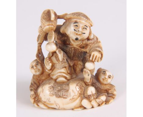 A FINE MEIJI PERIOD JAPANESE IVORY NETSUKE depicting three figures playing with balls 4cm high 3.5cm wide.