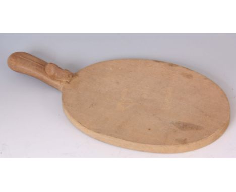 A ROBERT 'MOUSEMAN' THOMPSON OAK BREADBOARD with a raised handle having a carved mouse and adzed top 40cm wide 