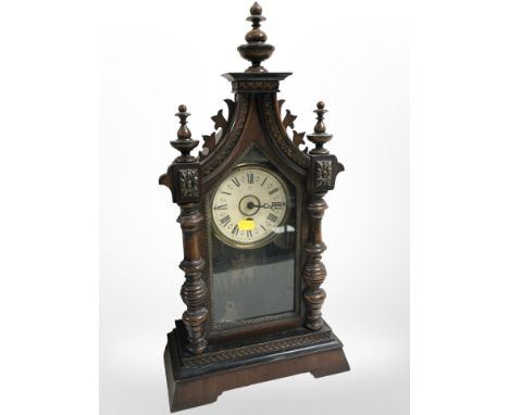 A 19th-century Junghans mantel clock in carved beech case, with pendulum and key, height 53cm.