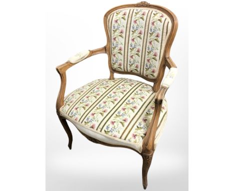 A carved beech salon armchair in tapestry fabric 