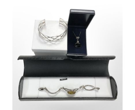 A silver Celtic-style bangle, a further silver and Baltic amber bracelet, and a pendant.