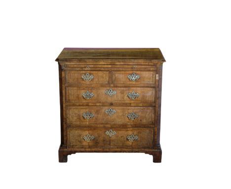 A GEORGE II WALNUT CHEST OF DRAWERS with a quarter veneered and crossbanded top over a brushing slide and an arrangement of t