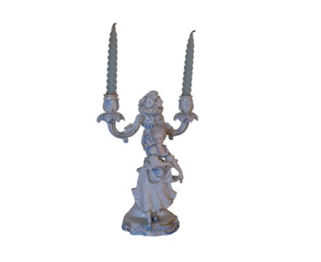 A DRESDEN STYLE PORCELAIN TABLE CANDELABRA modelled as a young lady dancing, surmounted by a twin branch candelabra, the crea