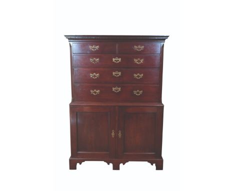 A GEORGE II MAHOGANY CHEST ON CHEST of unusual form, the upper section with a moulded and dentilled cornice over two short an