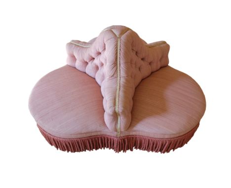 A VICTORIAN CONVERSATION SETTEE of trefoil form, with deep button floral upholstery and fringed border, on turned legs termin