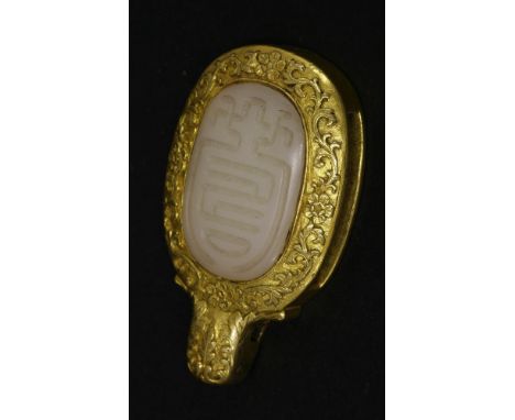 An attractive jade and gilt metal Belt Buckle,mid Qing, the central white jade boss carved with the archaic shou character an