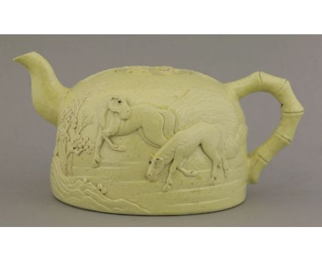 A yellow-glazed teapot, Republic period (1912-1949), moulded with two horses in a continuous landscape of rocky mountains and