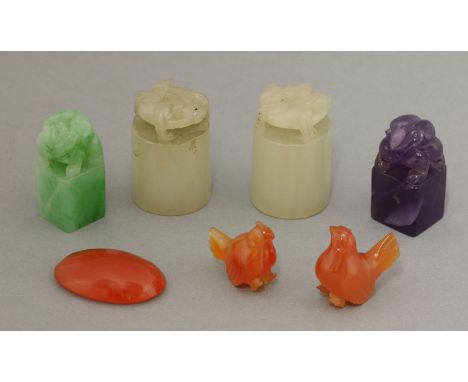 Hard stones, a pair of pale-grey jade seals, 2.9cm; two others of square section of jadeite and purple, 2.7cm; a carnelian co