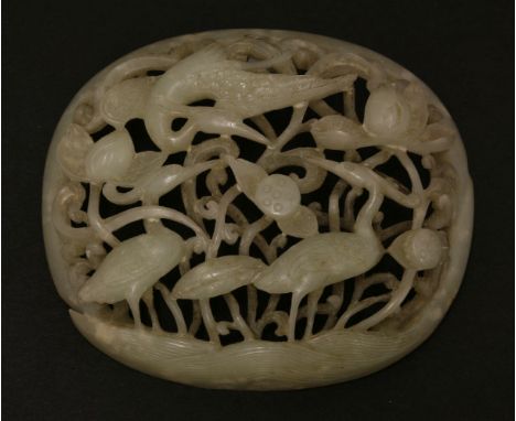 A carved and pierced jade Appliqué,Yuan/Ming (13th/14th century), of oval, domed form with two egrets wading through a thicke