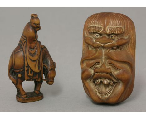 A wood Netsuke,an hilariously laughing mask, topped by a shishi, its eyes inlaid in mother-of-pearl and with black pupils, en
