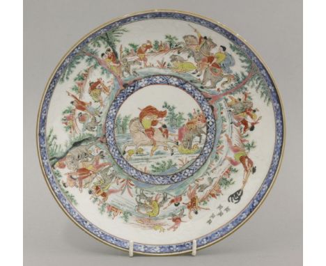 A Dutch decorated Saucer Dish,early 18th century, finely enamelled with hunting scenes divided by tall trees against an anhua