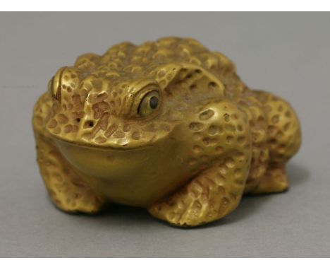 A gilt wood toad, 20th century, naturalistically carved with inlaid eyes, 5cm; and a hardwood netsuke, of a shishi head, mode
