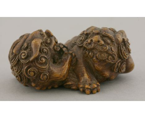 An attractive bamboo Carving,mid 19th century, of two shishi squabbling in a ring over a brocade ball, the bodies with tight 