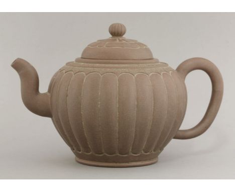 A Yixing teapot, 20th century, of lobed form beneath key fret and thread borders, the cover with flower petals, impressed sea