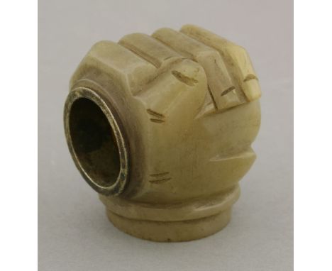 A carved jade walking stick mount, late 19th century, carved as a fist enclosing a rod, 4cm