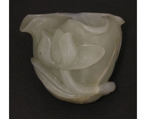 A jade small lotus Cup,18th/19th century, carved in relief with flowering lotus leaves and veins, the stone of pale celadon t