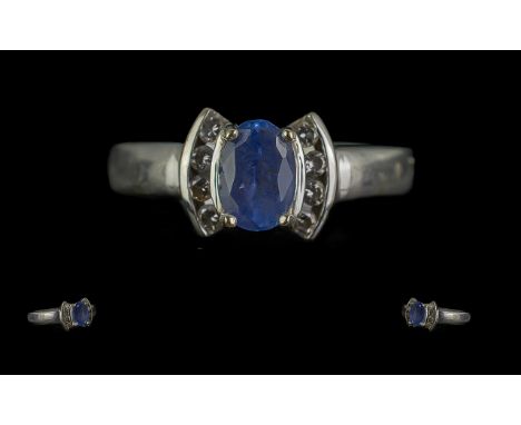 14ct White Gold Ring set with an oval shaped Tanzanite in a bow design with four small diamonds at each side. Hallmarked, rin