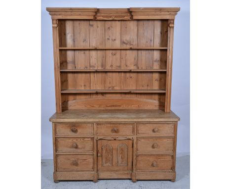 Pine dresser, three shelf rack over seven drawers and central cupboard, W153cm x H208cm.