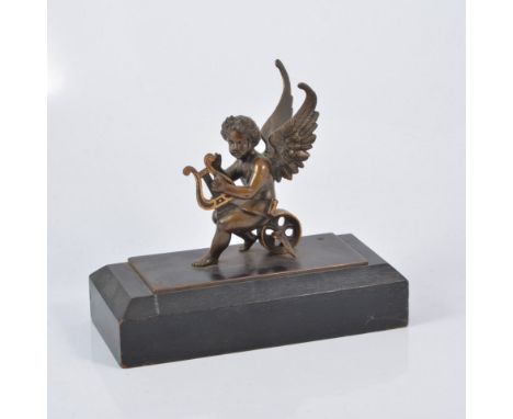 A cast bronzed metal model of a winged cherub playing a lyre, oak plinth, 20cm.