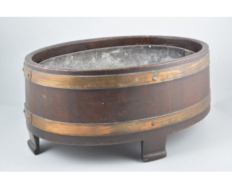 Oak oval jardiniere, brass banded, labelled R A Lester, Dursley, width 46cm 