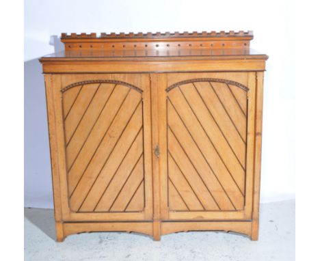 Gothic Revival oak cabinet, castellated low back rectangular top, moulded edge, plain frieze, two carved panelled doors and s