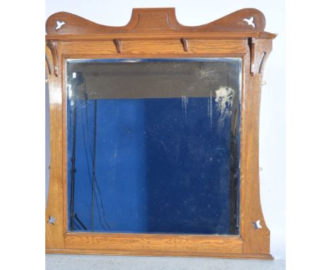 Large Art Nouveau style mirror, shaped and pierced oak frame, with a shelf above a square bevelled plate, 127 x 125cm.