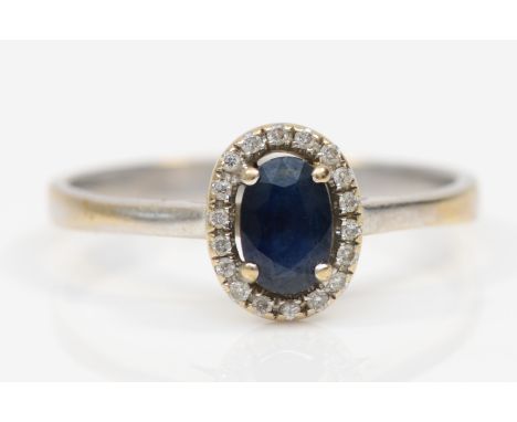 An 18k white gold sapphire and brilliant cut diamond cluster ring, P, 2.5gm. 