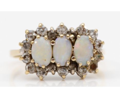 A 9ct gold three stone opal and white stone dress ring, flashes of red, blue and green, O, 2.3gm. 