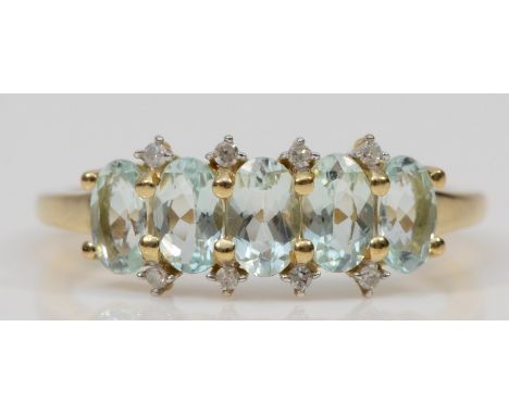 A 9ct gold five stone aquamarine dress ring, with eight cut diamond accents, M, 1.7gm. 