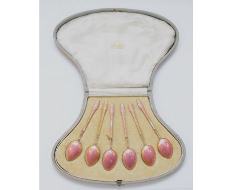 A set of Art Deco silver gilt and pink gouache enamel tea spoons, London import 1920, 65gm, cased.Each spoon has some enamel 