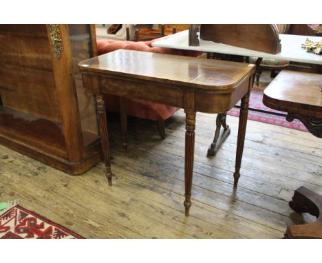 An early 19th Century inlaid mahogany card table on turned fluted legs (top as found)