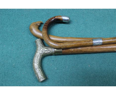 Three walking sticks, one with hallmarked silver end, one with a birds head handle and a modern drinking flask stick