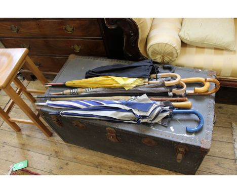 A collection of vintage wooden handle umbrellas and a late 19th Century silver topped cane
