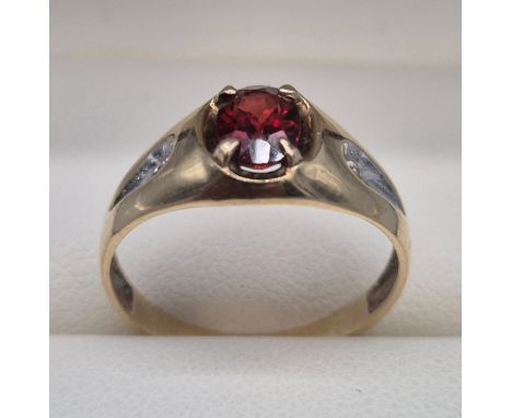 Yellow gold ring fitted with an oval cut garnet and two small round cut diamonds. Marked rubbed. 2grams. Ring size P. 