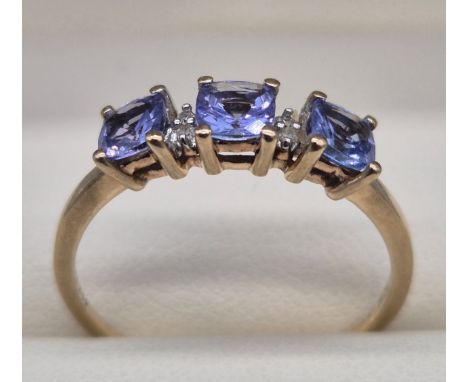 10ct yellow gold ring fitted with four emerald cut purple gem stones and four round cut white stones. 1.72grams. Ring size P.