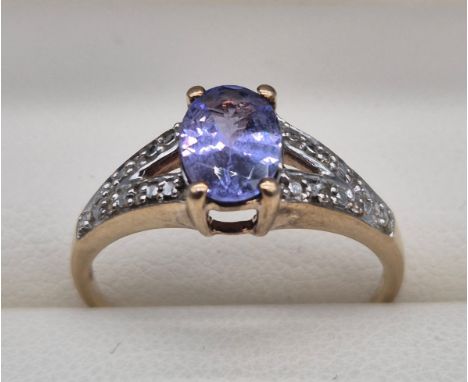 9ct yellow gold ring fitted with an oval cut purple gem stone ring and diamond cluster shoulders. 2.04grams. Ring size O. 