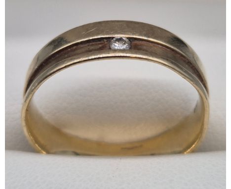 9ct yellow gold band ring fitted with a single round cut diamond. 3.61grams. Ring size Q. 