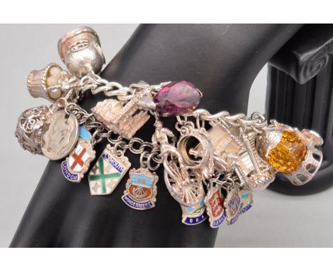 Silver charm bracelet containing a large quantity of silver charms. Together with a silver charm bracelet containing silver a